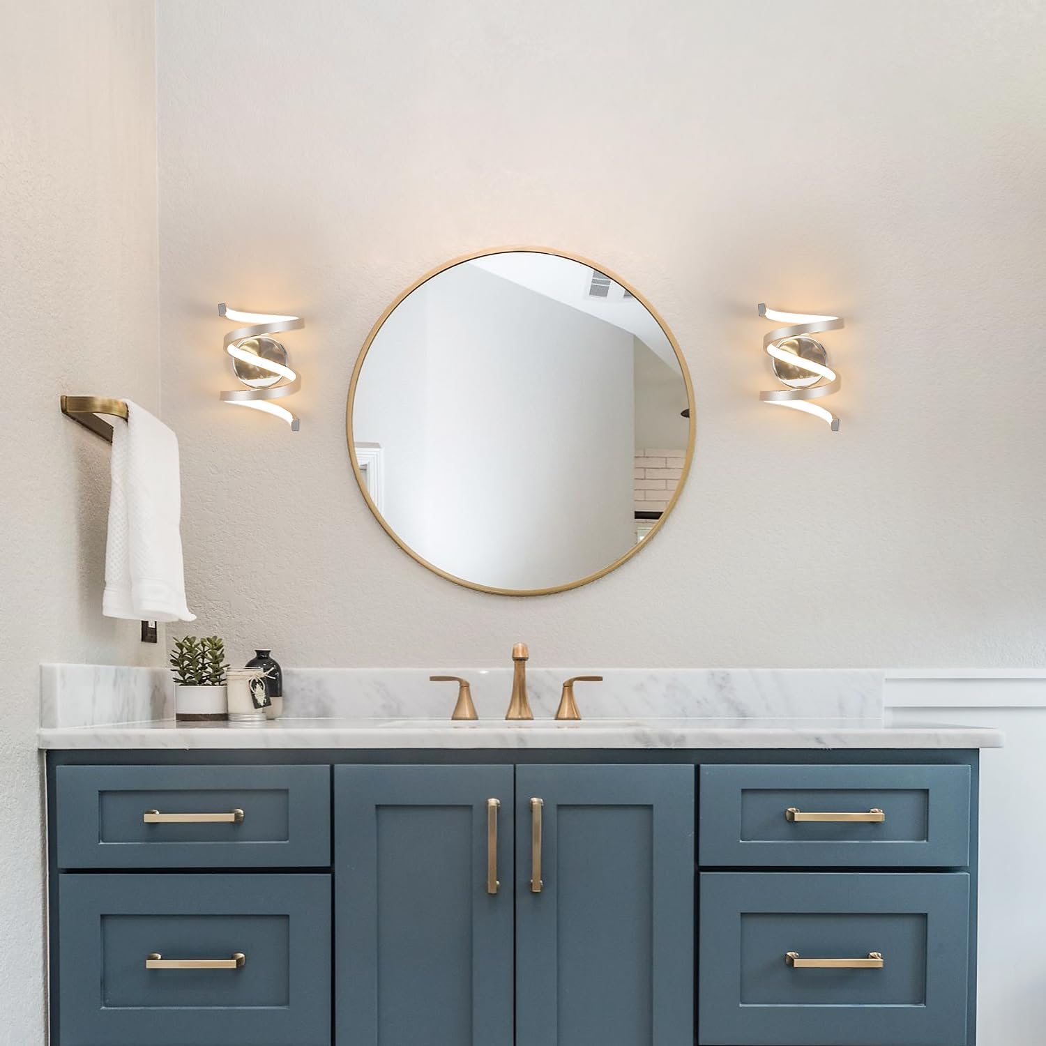 Bathroom vanity with blue cabinets, round mirror, and marble countertop.