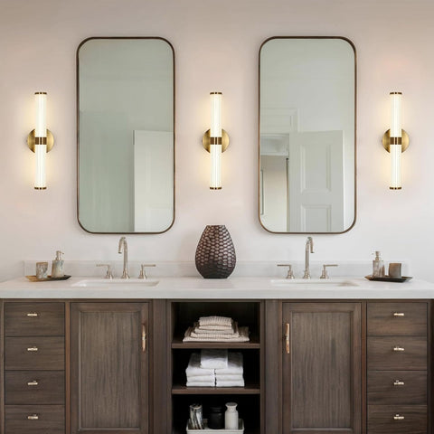 Bathroom vanity with two mirrors, lights, and various items on a white countertop.