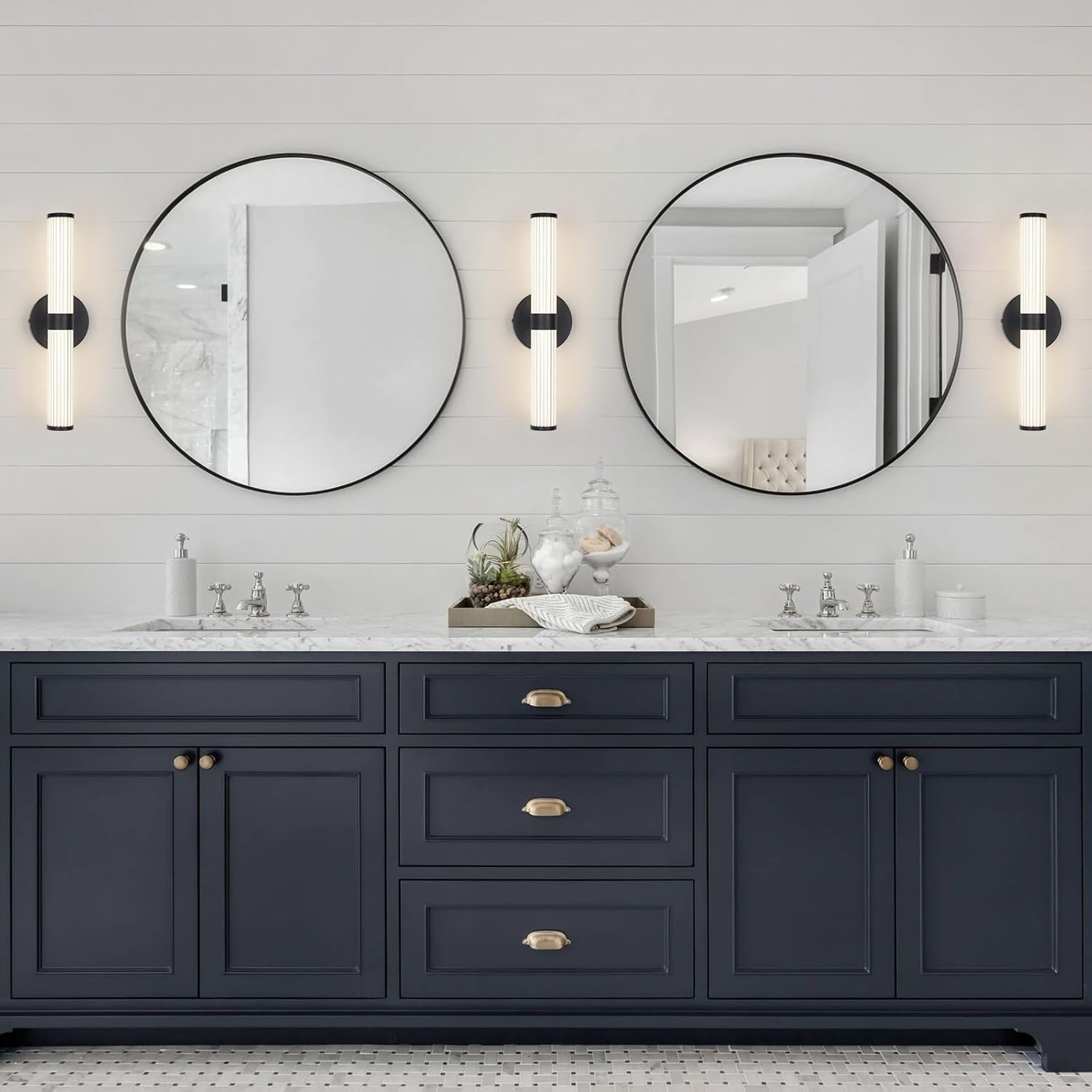 Bathroom vanity with two round mirrors, dark cabinets, and light fixtures.