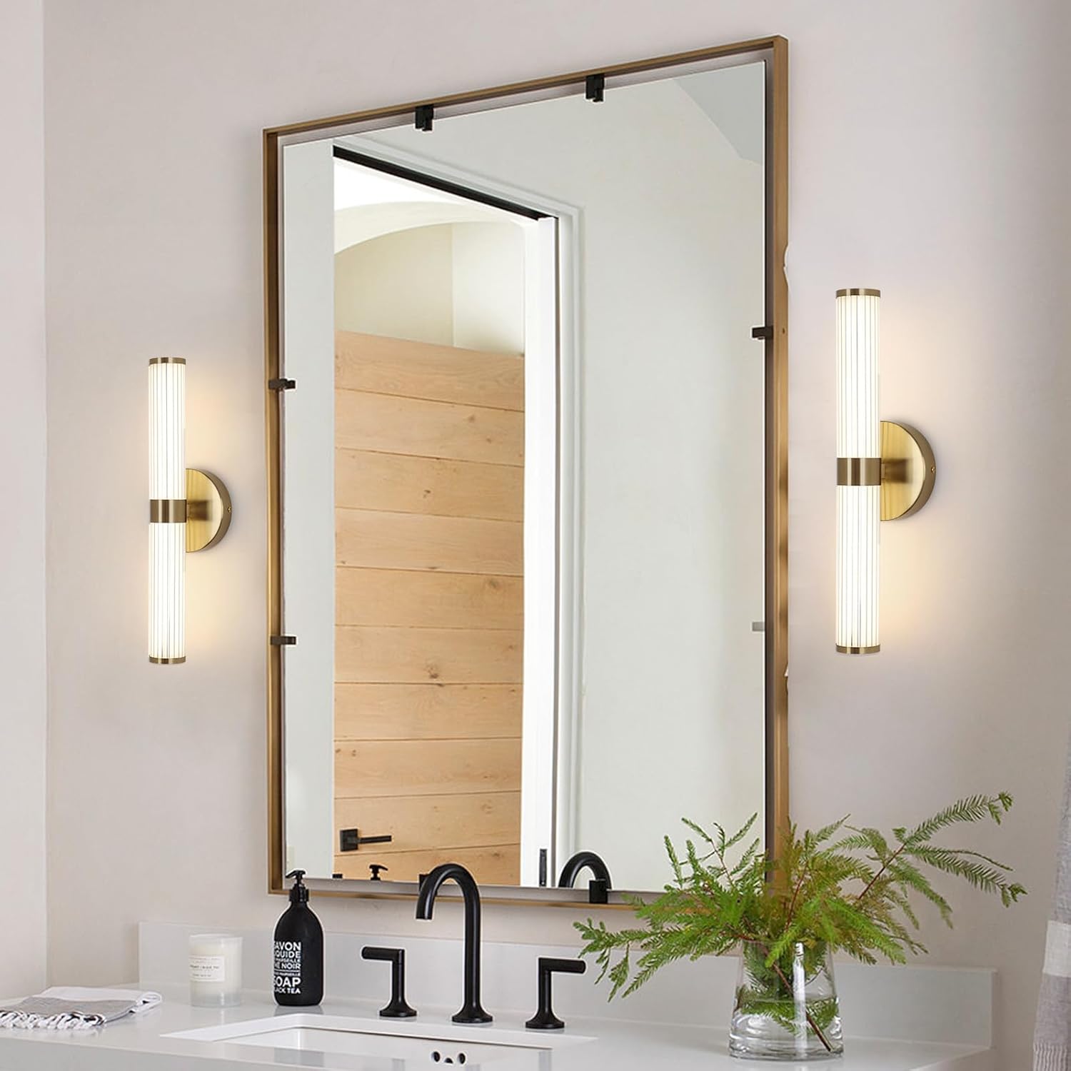 Bathroom with a large mirror, wall lights, and a plant on a counter.