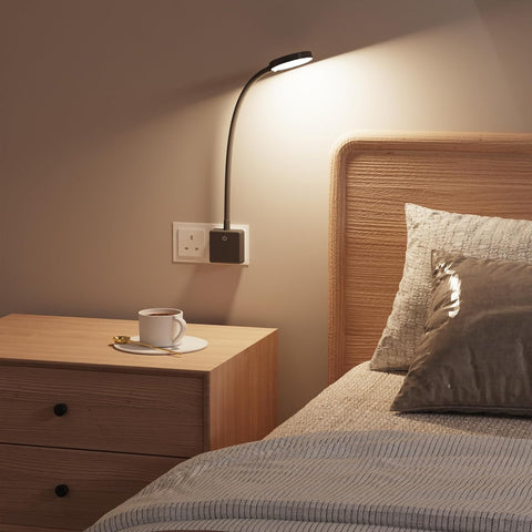 Bedroom scene with a nightstand, lamp, and bed with pillows.
