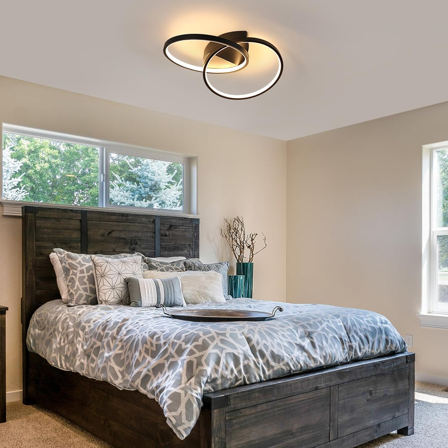 Bedroom with wooden bed, patterned bedding, and modern ceiling light fixture.
