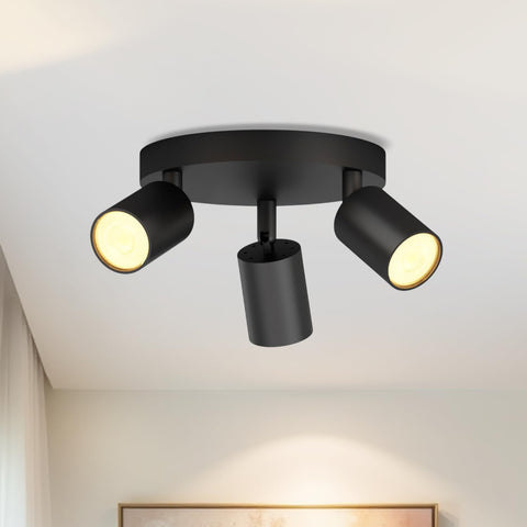 Black ceiling light fixture with three adjustable lights on a white ceiling.