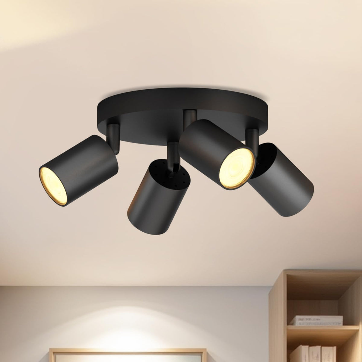 Black ceiling light fixture with three cylindrical lights on a beige ceiling.