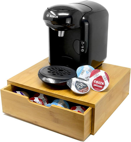 Black coffee maker with a wooden stand holding coffee pods on a white background