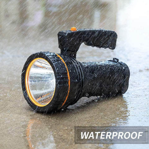 Black flashlight with orange rim being used in water, labeled 'Waterproof'.