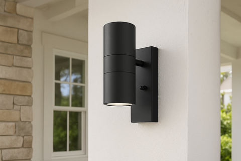 Black outdoor wall light fixture on a house exterior.