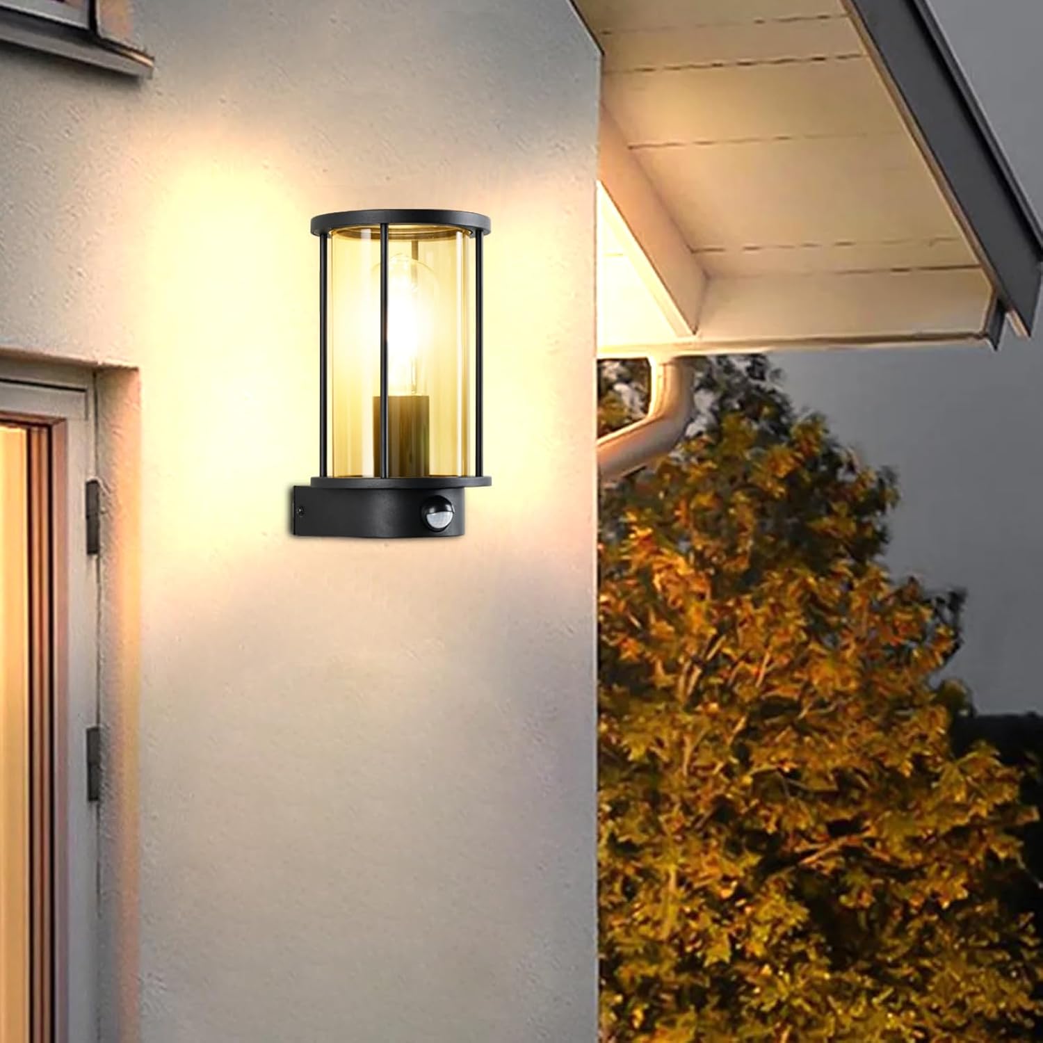 Black outdoor wall light fixture on a house exterior with a tree in the background.