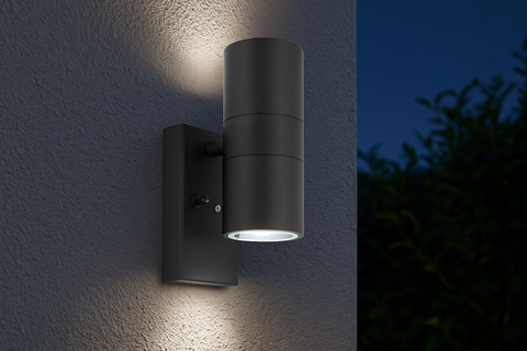 Black outdoor wall light fixture on a textured wall with a dark background