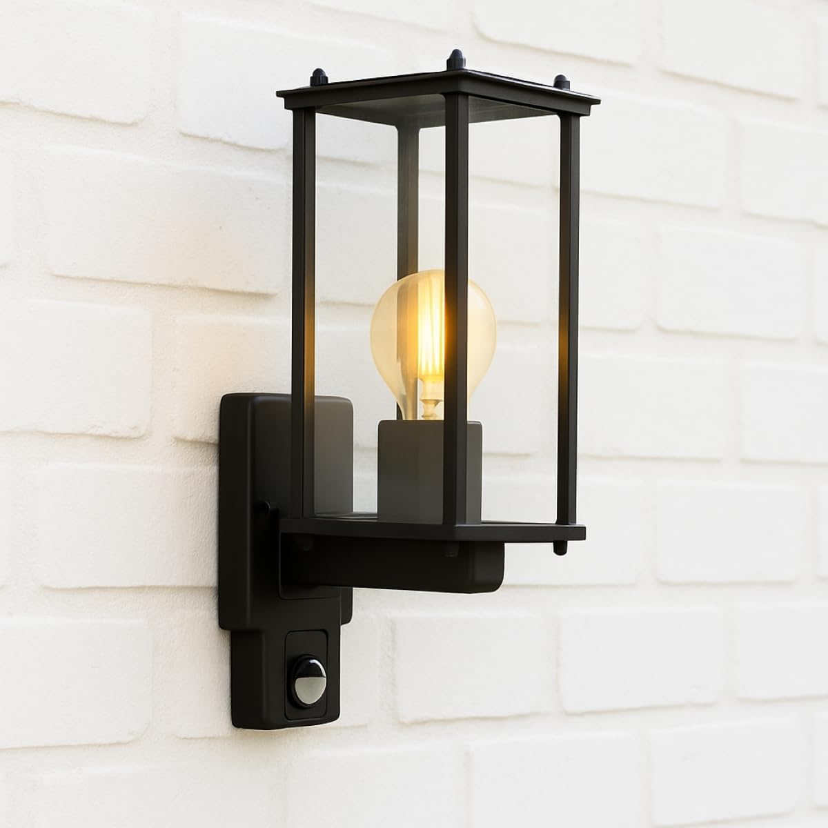 Black outdoor wall light fixture on a white wooden wall