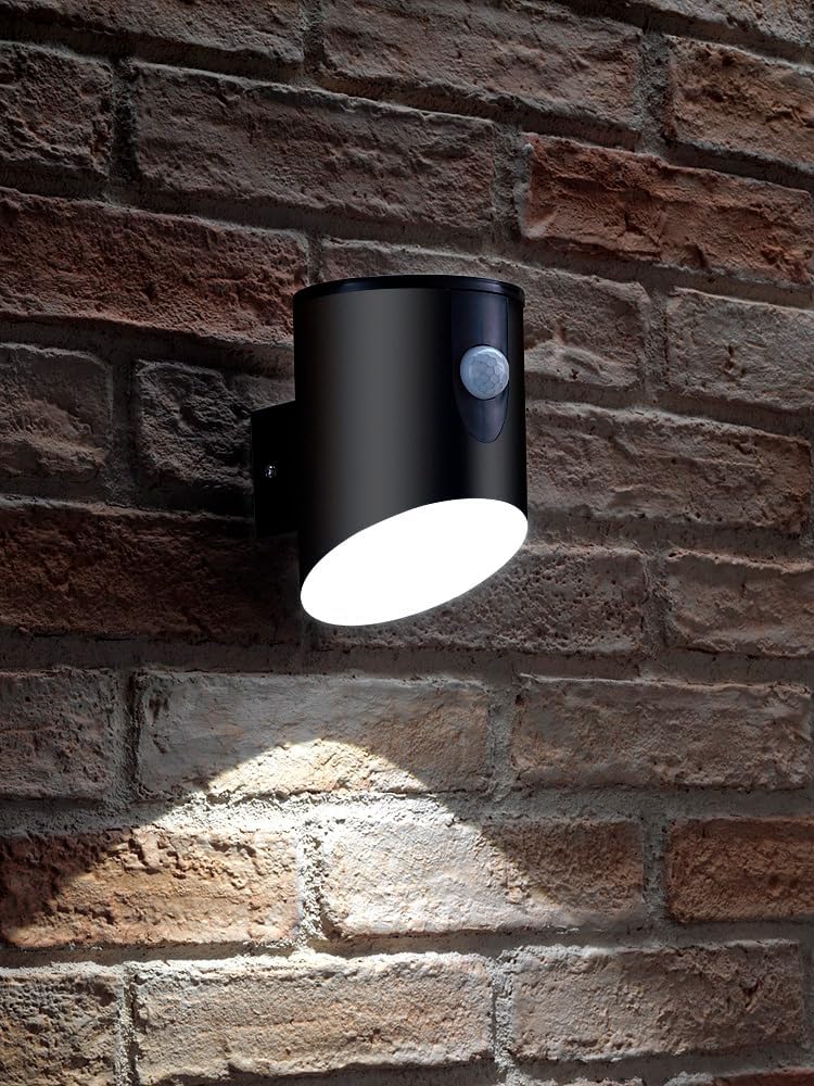 Black outdoor wall light with motion sensor on a brick wall