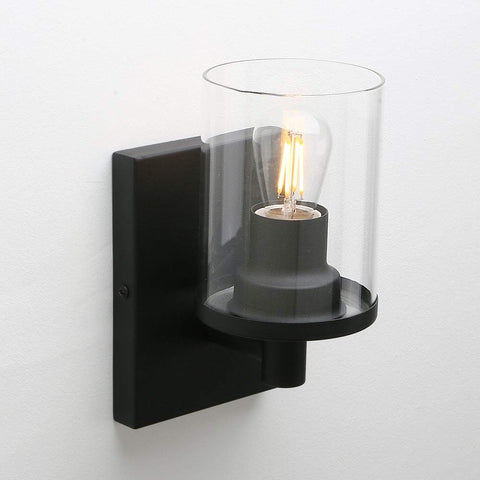 Black wall-mounted light fixture with a clear glass shade on a white background