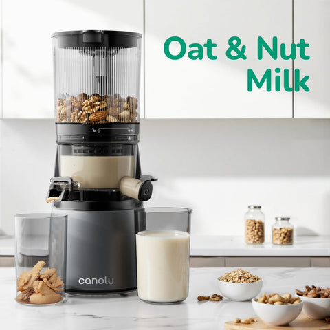 Canaly milk maker with ingredients and a glass of oat and nut milk on a kitchen counter.