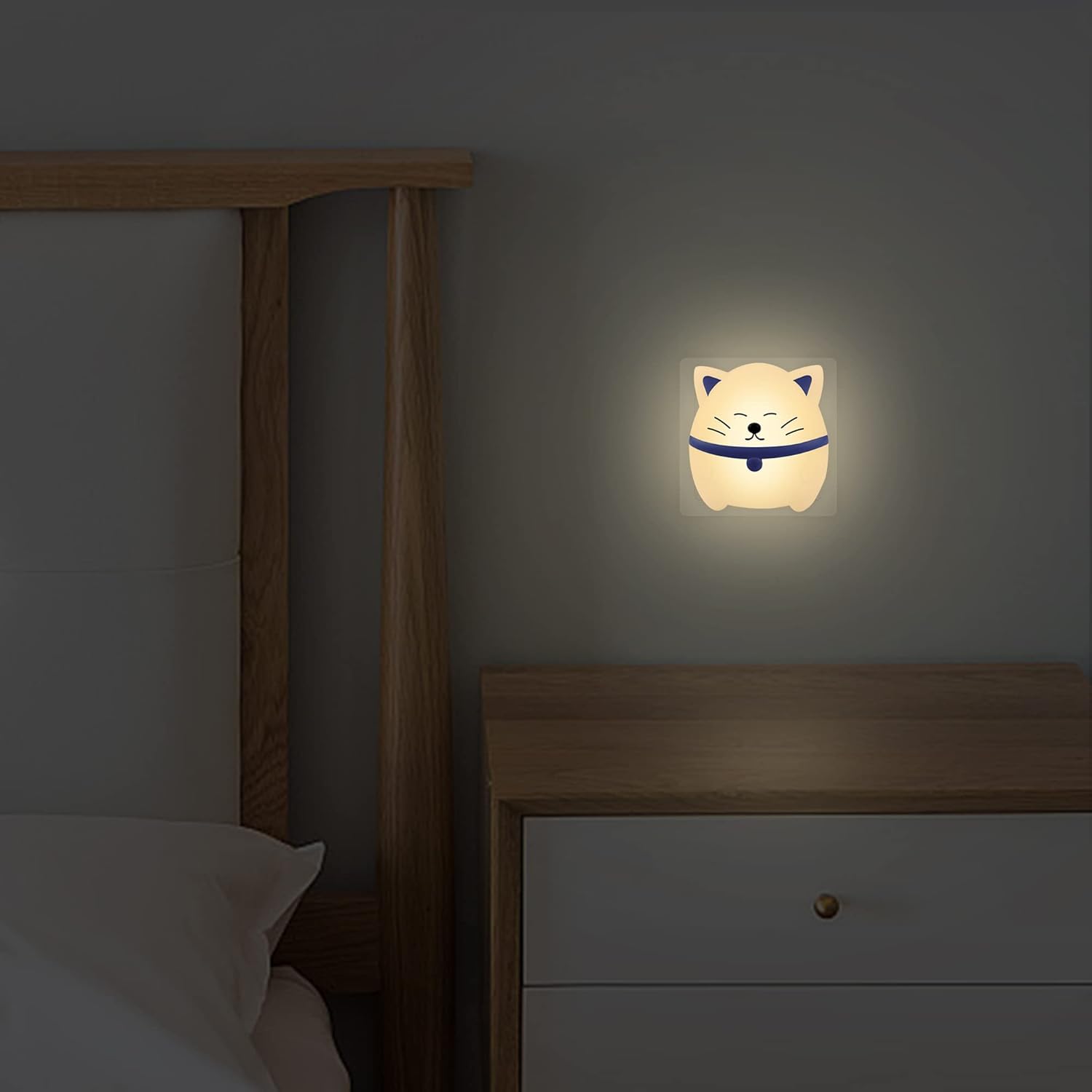 Cat-shaped night light on a wall next to a bed