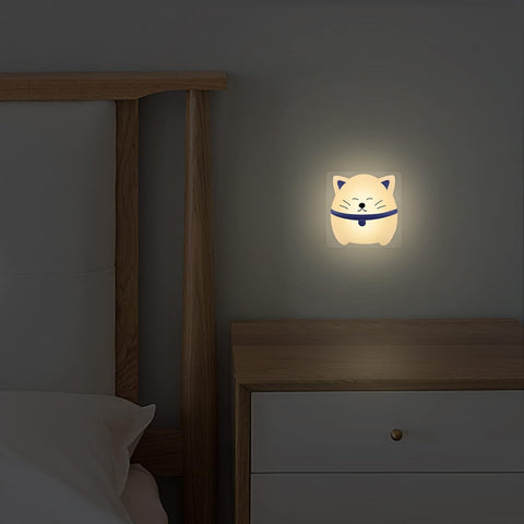 Cat-shaped night light on a wall next to a bed