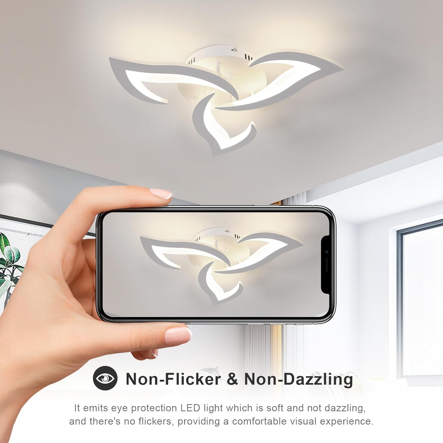Ceiling light fixture with a hand holding a phone showing its reflection, in a room setting.
