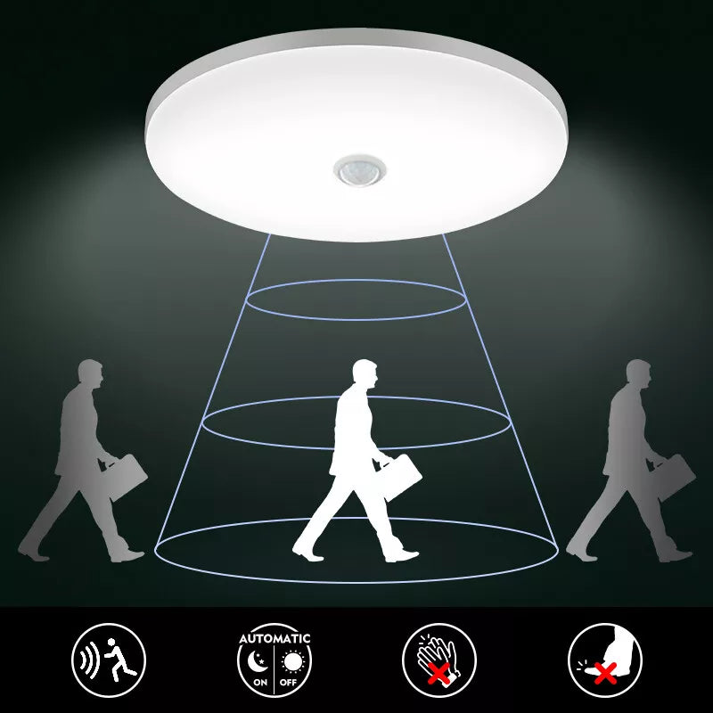 Ceiling light fixture with shadow projection of a person walking, on a dark background.