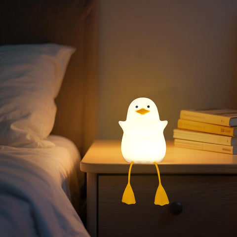 Chicken-shaped night light on a bedside table next to a bed and books