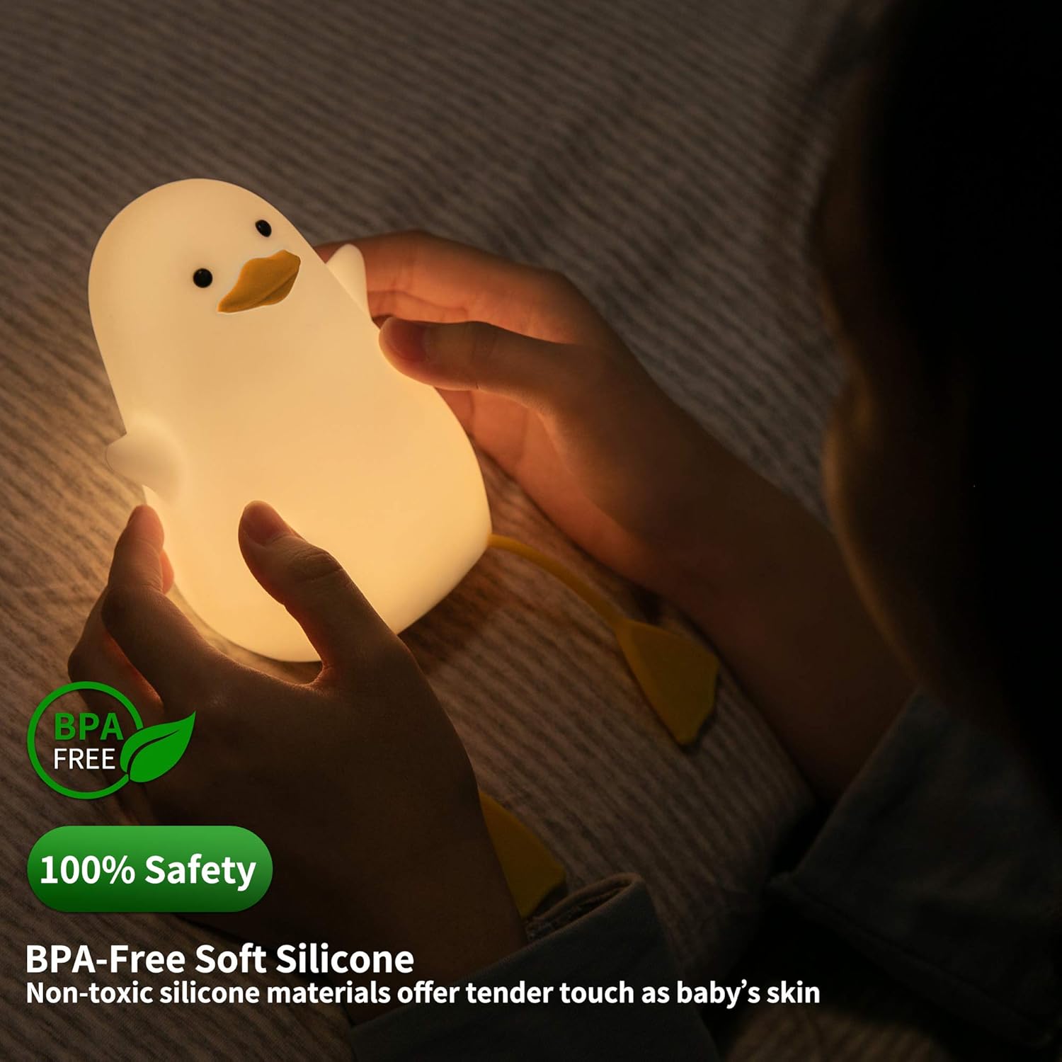 Child holding a duck-shaped night light with safety certification text.