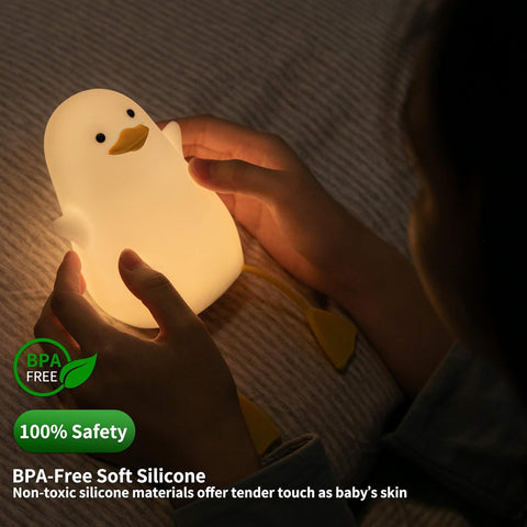 Child holding a duck-shaped night light with safety certification text.