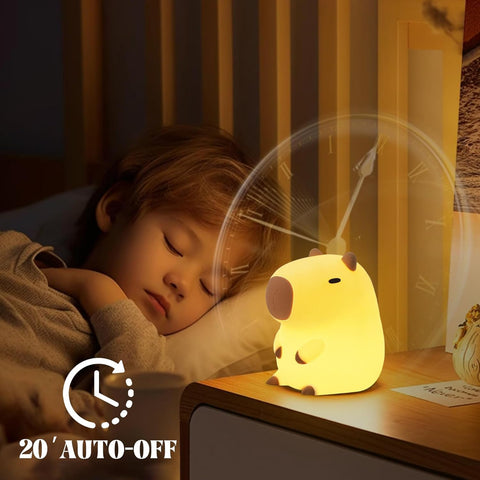 Child sleeping with a cartoon night light on a bedside table.