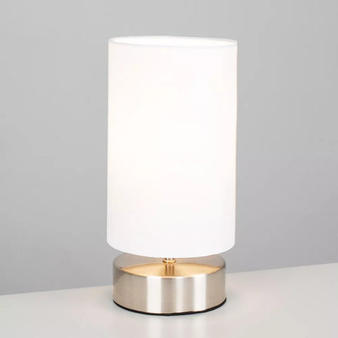 Compact 24cm bedside lamp next to a bed with white linens – UK home lighting.

