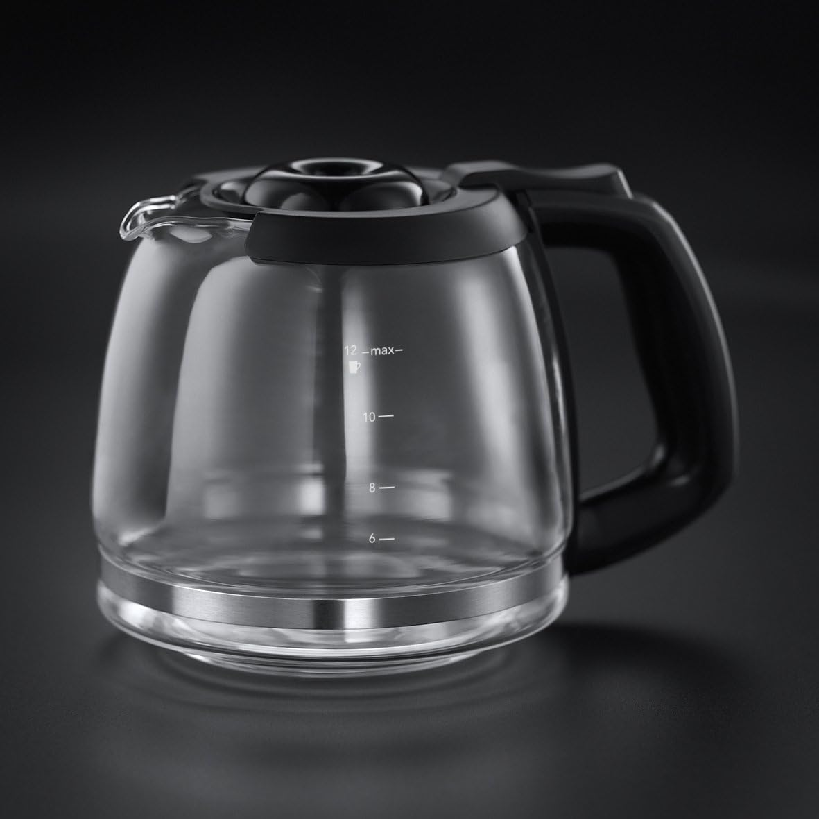 Clear glass coffee maker with black handle on a dark background
