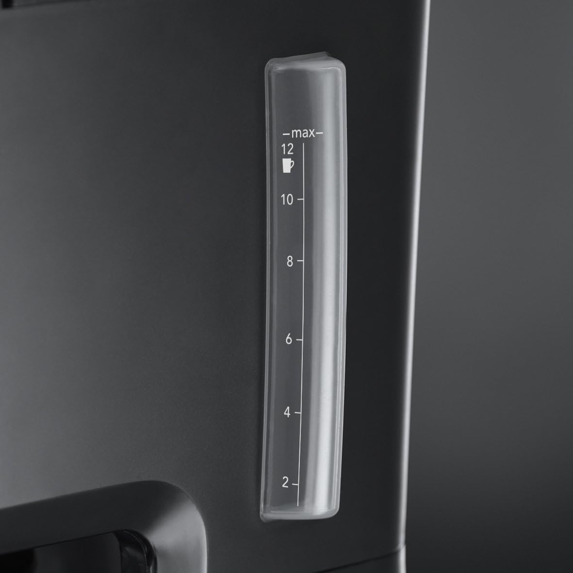 Clear measuring scale on a black appliance with a dark background
