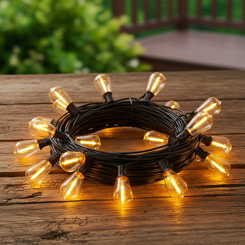 Coiled string of lights with warm yellow bulbs on a wooden surface