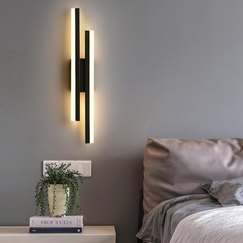 Black LED wall light installed in a contemporary bedroom setting