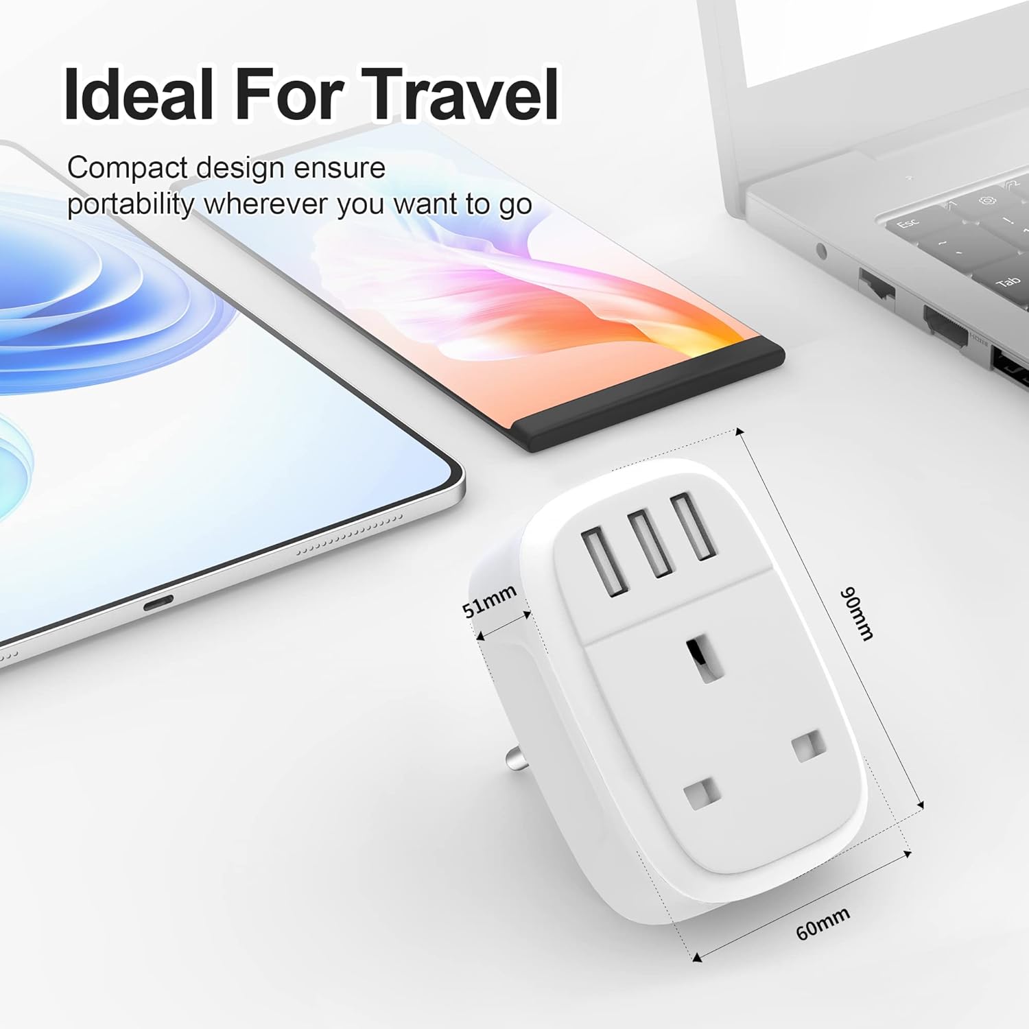 Compact travel adapter with dimensions displayed, next to a smartphone and laptop on a white surface.