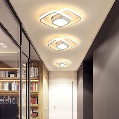 Modern ceiling lights in a hallway with bookshelves on one side