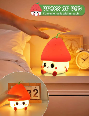 Cute plush night light with red cap on a bedside table, hand reaching out to press it.
