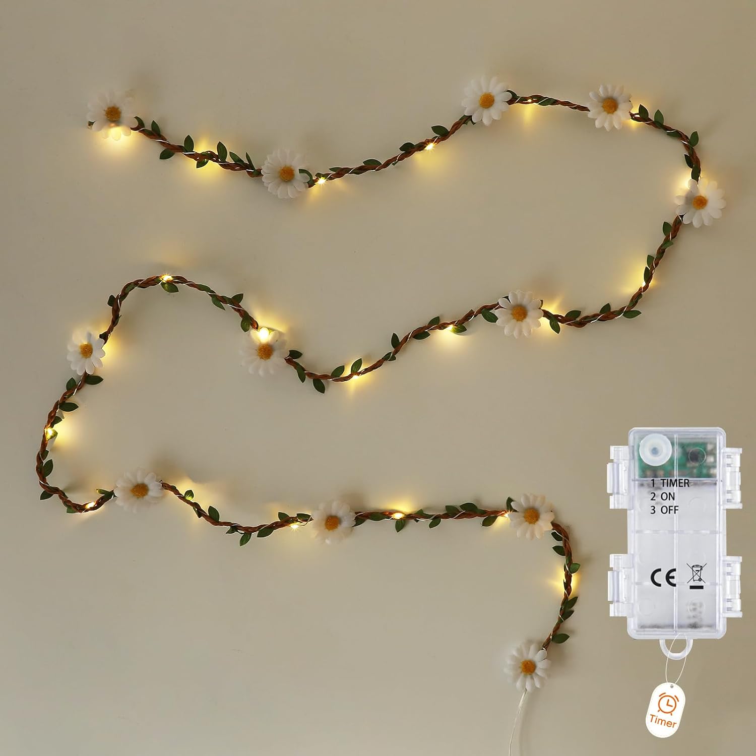 String lights with floral decorations and a remote control on a beige wall.