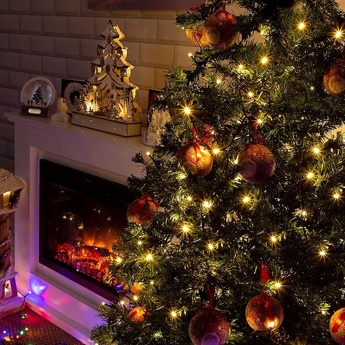 Decorated Christmas tree with lights in front of a fireplace