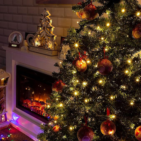 Decorated Christmas tree with lights in front of a fireplace