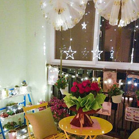 Decorated room with flowers, string lights, and a window with star decorations.