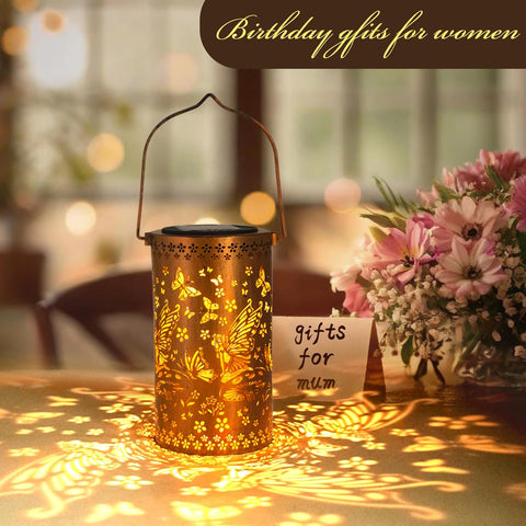 Decorative lantern with butterfly design and a bouquet of flowers on a blurred background.