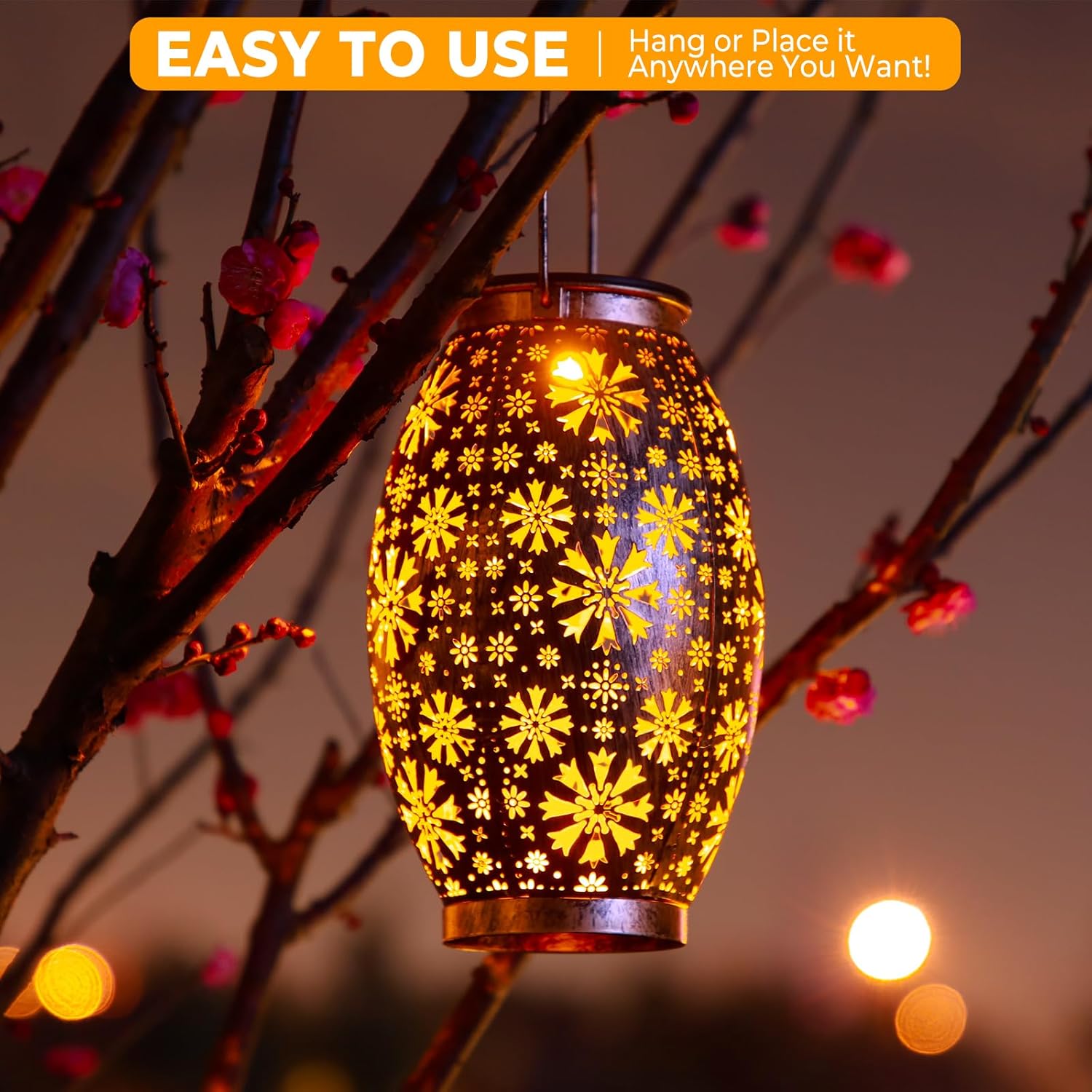 Decorative lantern with floral pattern hanging on a branch at night