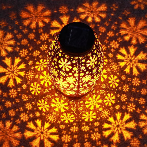 Decorative lantern with floral patterns casting shadows on a wall
