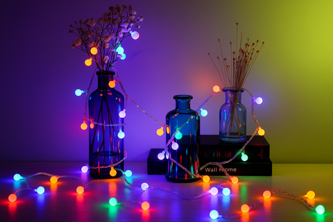 Decorative setup with blue bottles and colorful string lights against a gradient background