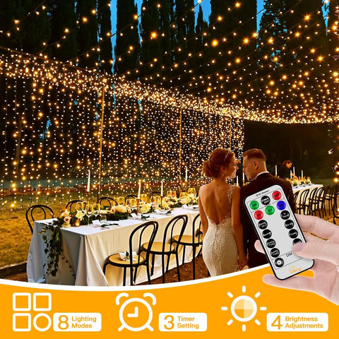 Decorative string lights with a remote control, set up for an outdoor event with a couple and table.