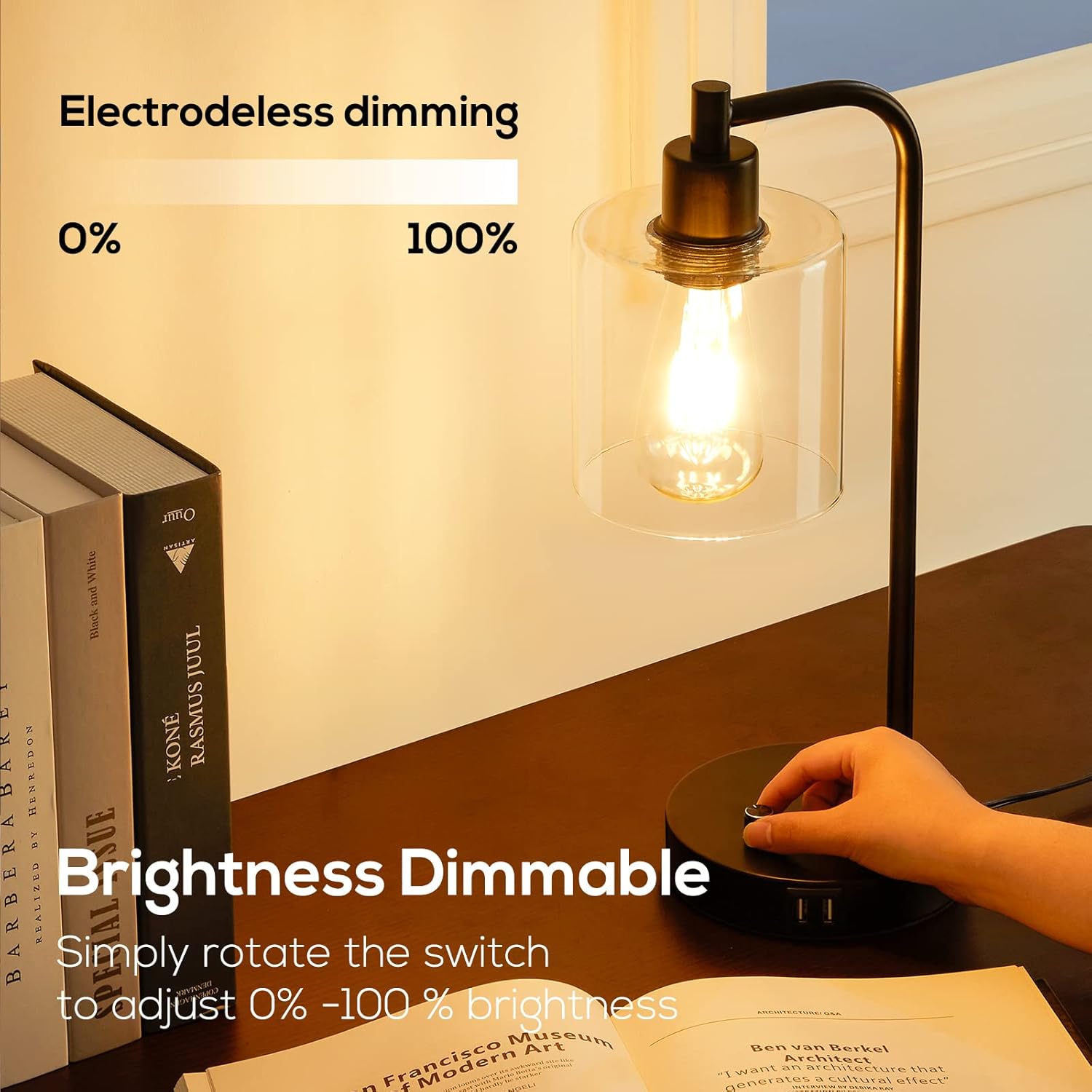 Desk lamp with a hand adjusting the brightness switch, books and an open book in the background.