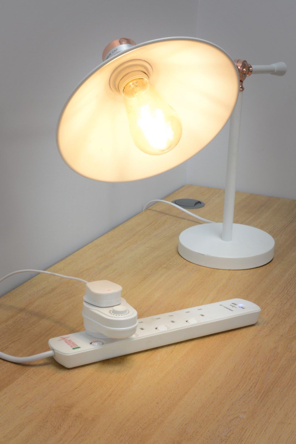 Desk lamp with a light bulb on a wooden surface