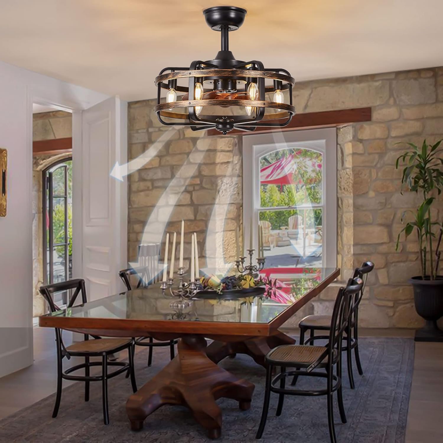 Dining room with a large wooden table and chairs, stone wall, and ceiling fan.