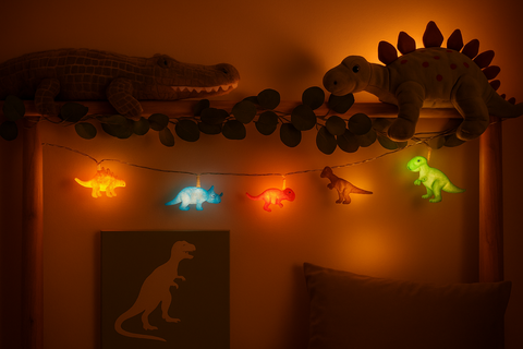 Dinosaur-themed room decor with plush toys and string lights on a wall.