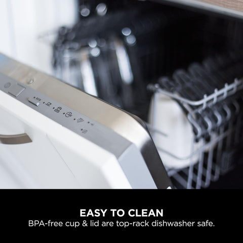 Dishwasher with an open door showing a BPA-free cup and lid inside.