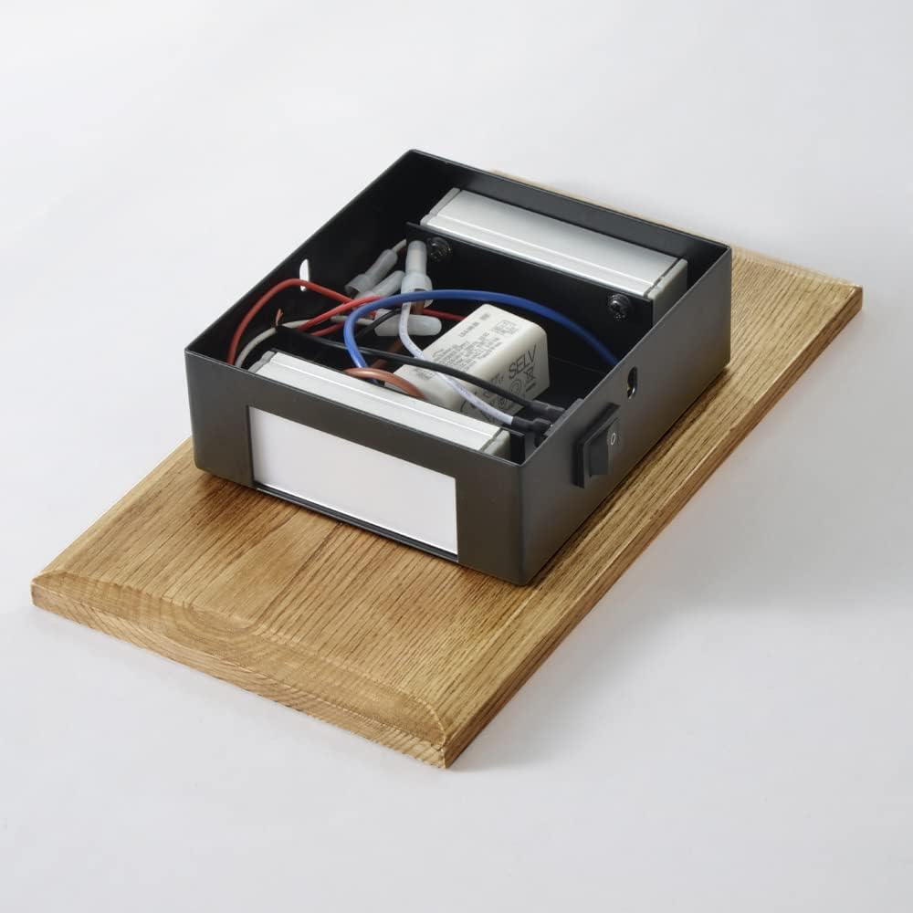 Electrical box with wires on a wooden platform against a white background