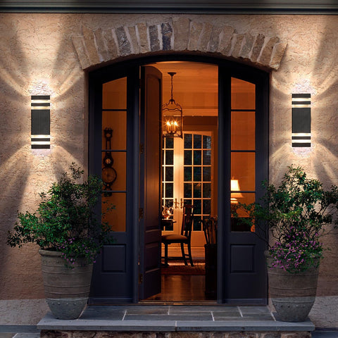 Elegant entrance to a house with decorative lights and plants.