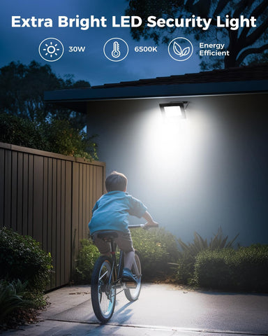 Extra bright LED security light illuminating a pathway with a child on a bike at night.